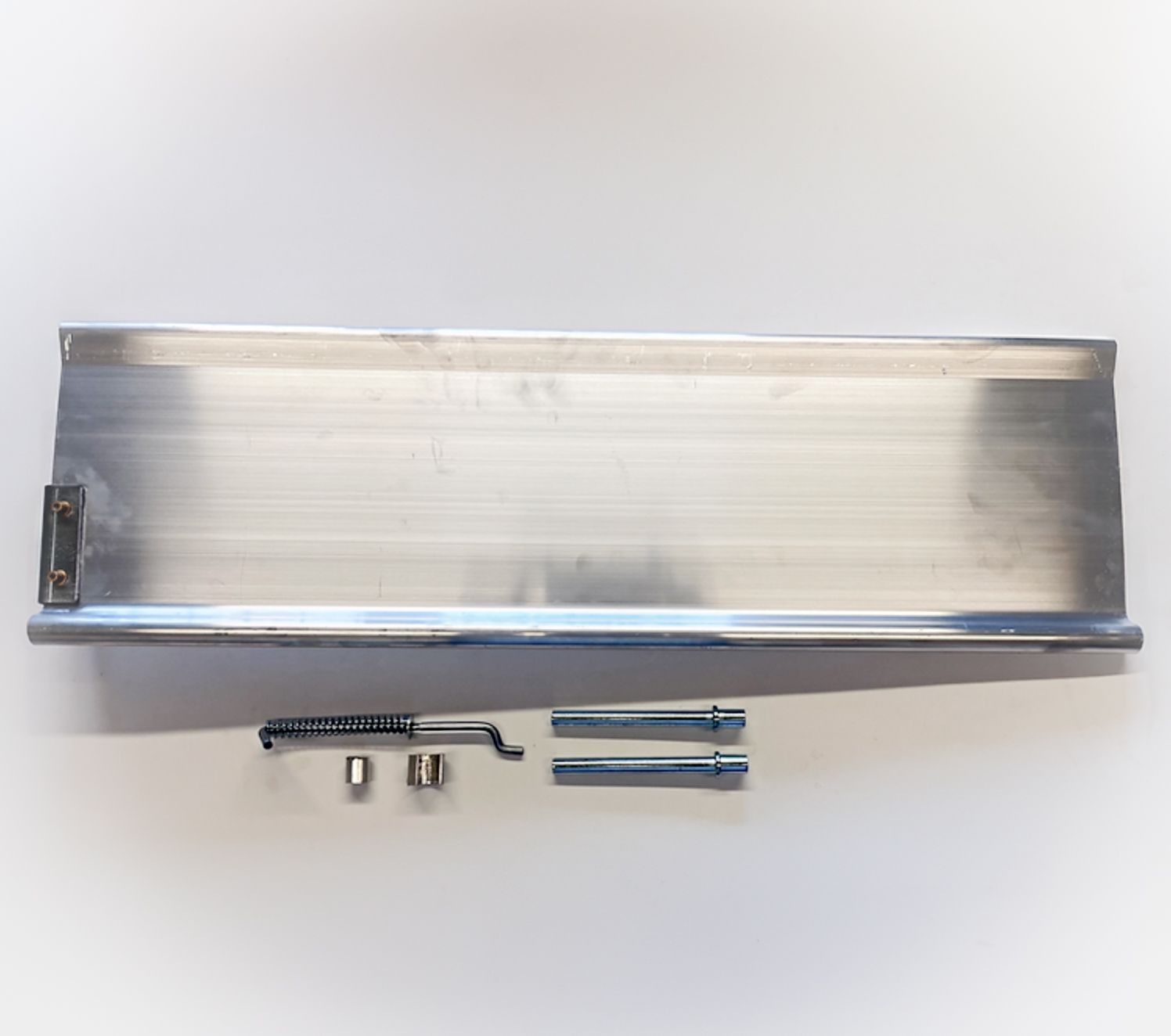Aluminum metal shelf with mounting hardware and tools laid out on a white surface.