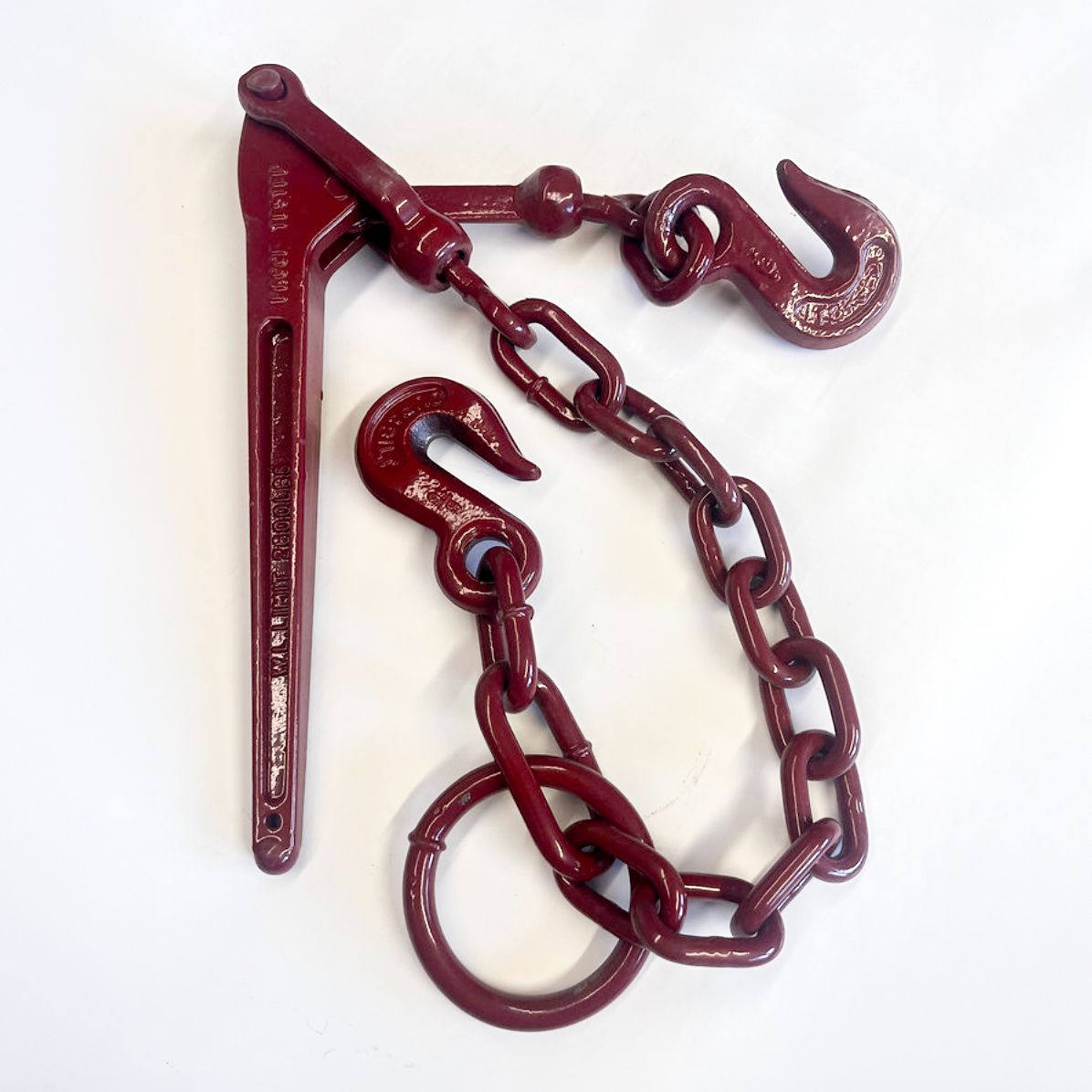 Red ratchet binder with chain and hooks, used for securing loads.