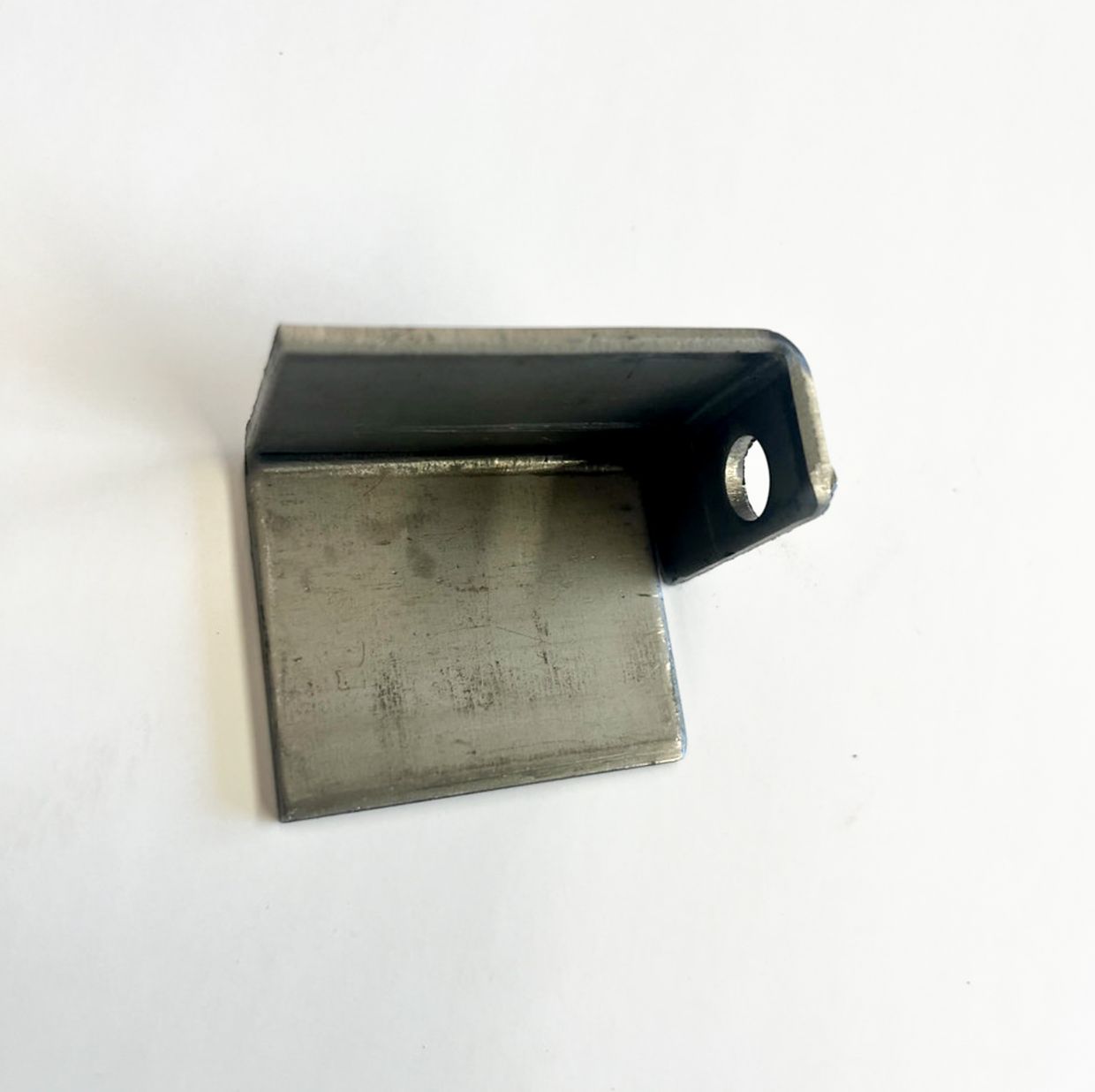 Metal bracket with a bent shape and a hole.