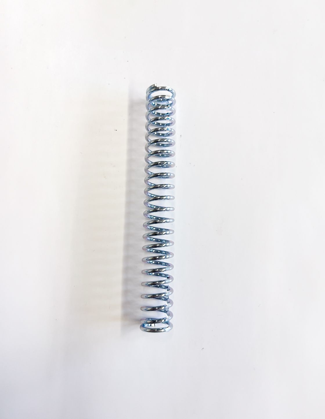Silver metal spring on a white background.
