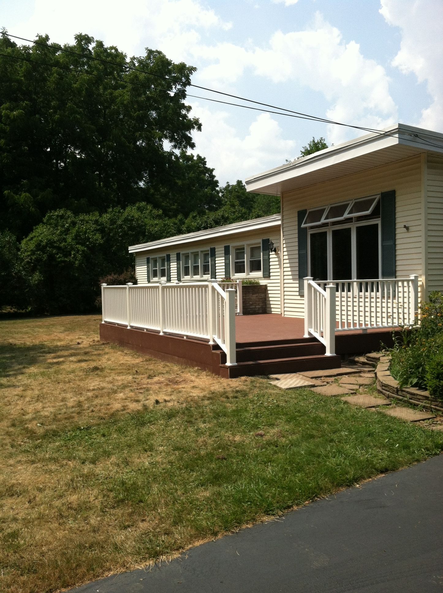 A white house with a large deck and stairs