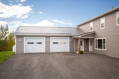 A large house with two garage doors and a driveway
