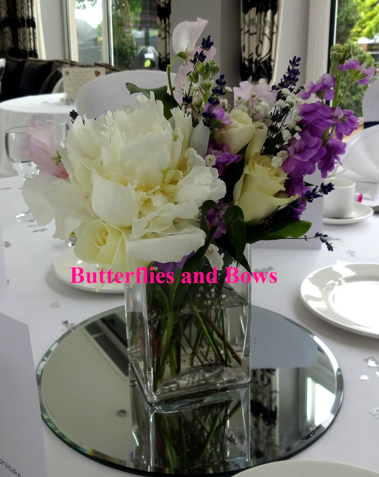 Wedding flowers - Ivory and purple blooms with a mirrored base