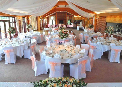 Pretty peach colour theme with chair covers, bows, ceiling drapes, and flower arrangements all contributing to a fresh and attractive overall effect at Westerham Golf Course, Kent