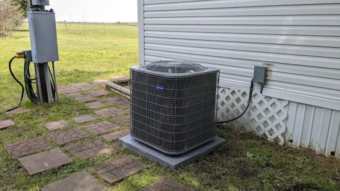 An air conditioner is sitting on the side of a house.