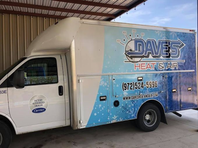 A daves heat and air truck is parked under a roof