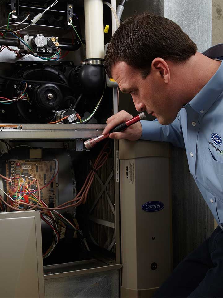 A man is working on a carrier air conditioner