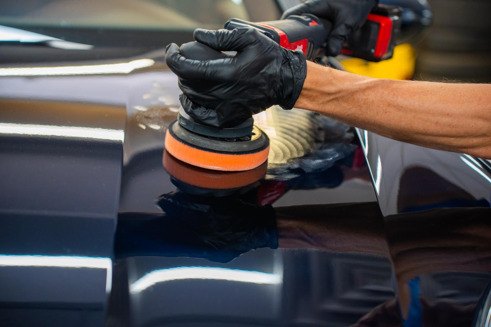 A person is polishing a car with a machine - Brandon Cavender