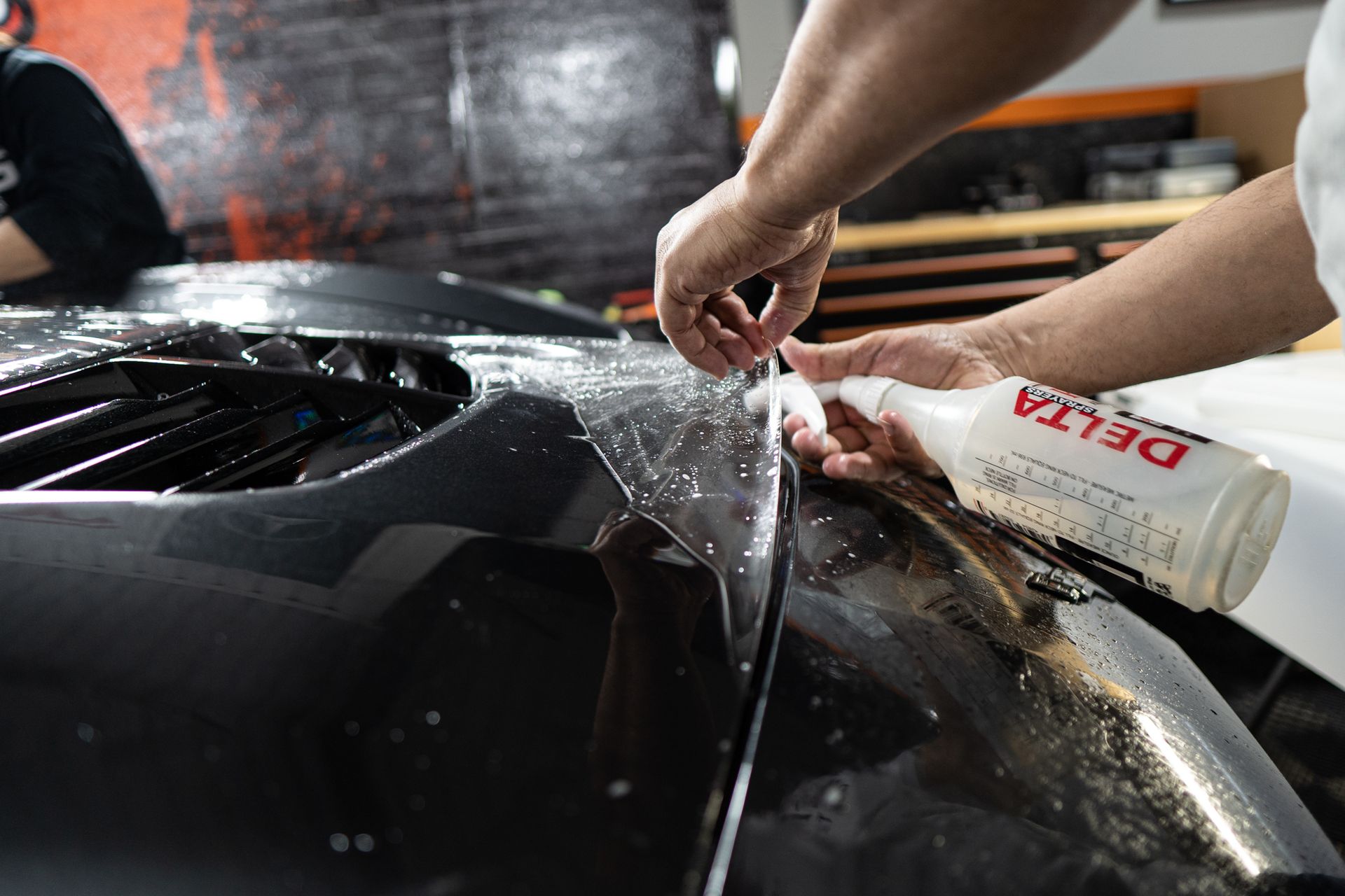 A person is working on a matte ppf car.