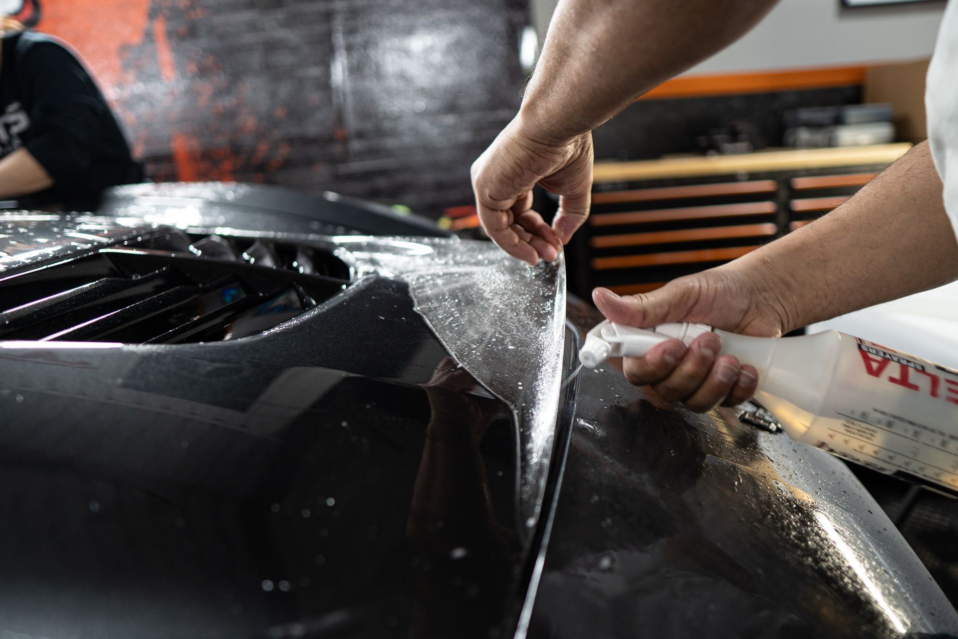 A person is working on a matte ppf car.