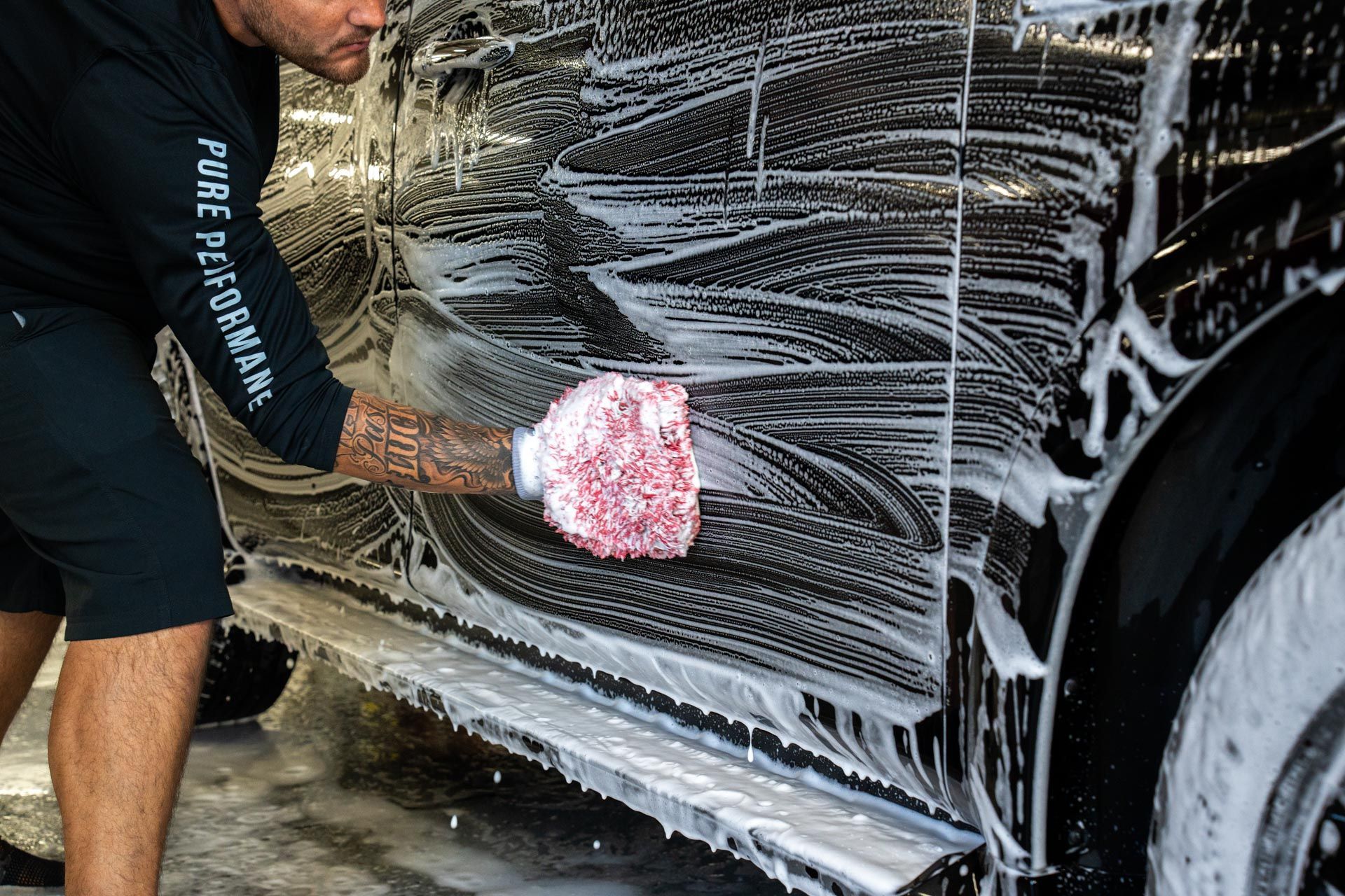 Full Detailing - a man is washing a car with a sponge and foam Brandon Cavender