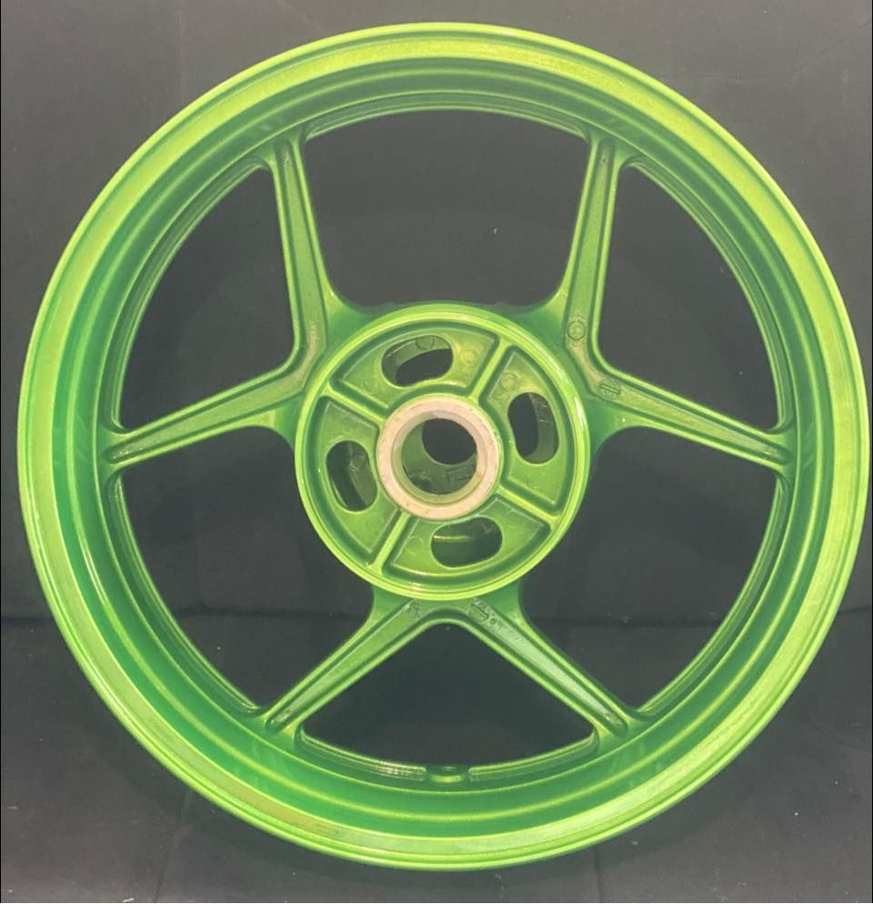 A close-up of a green motorcycle wheel.