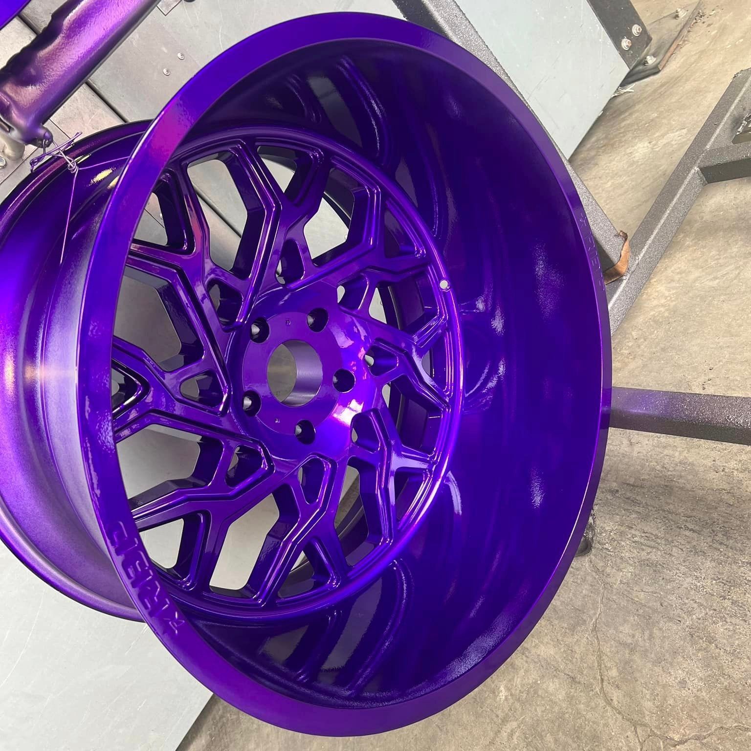 A purple wheel is sitting on a metal stand.
