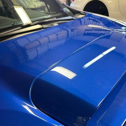 A close up of the hood of a blue car.