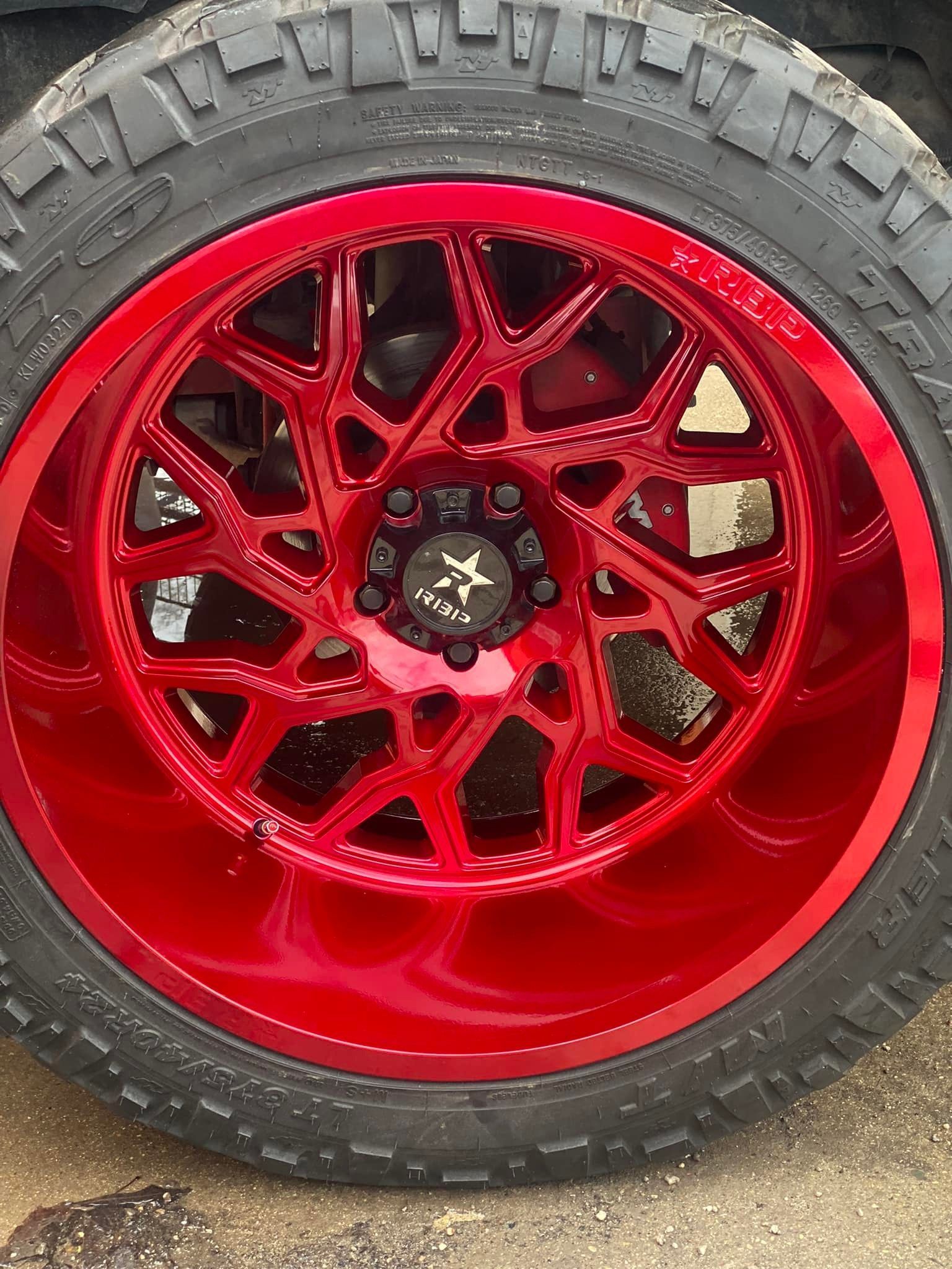 a close-up of a red wheel and tire on a car.