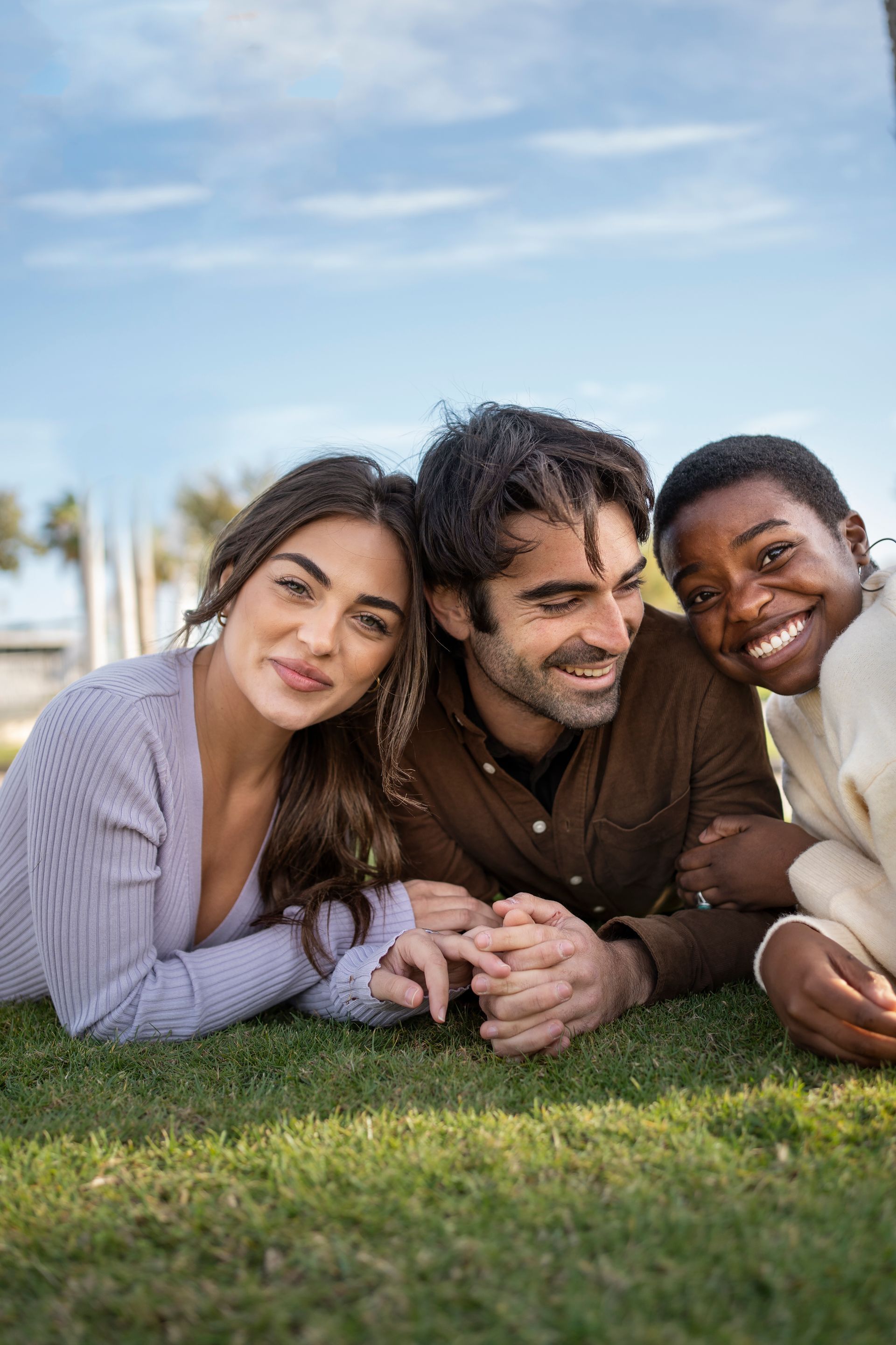 A family is laying on the grass together.