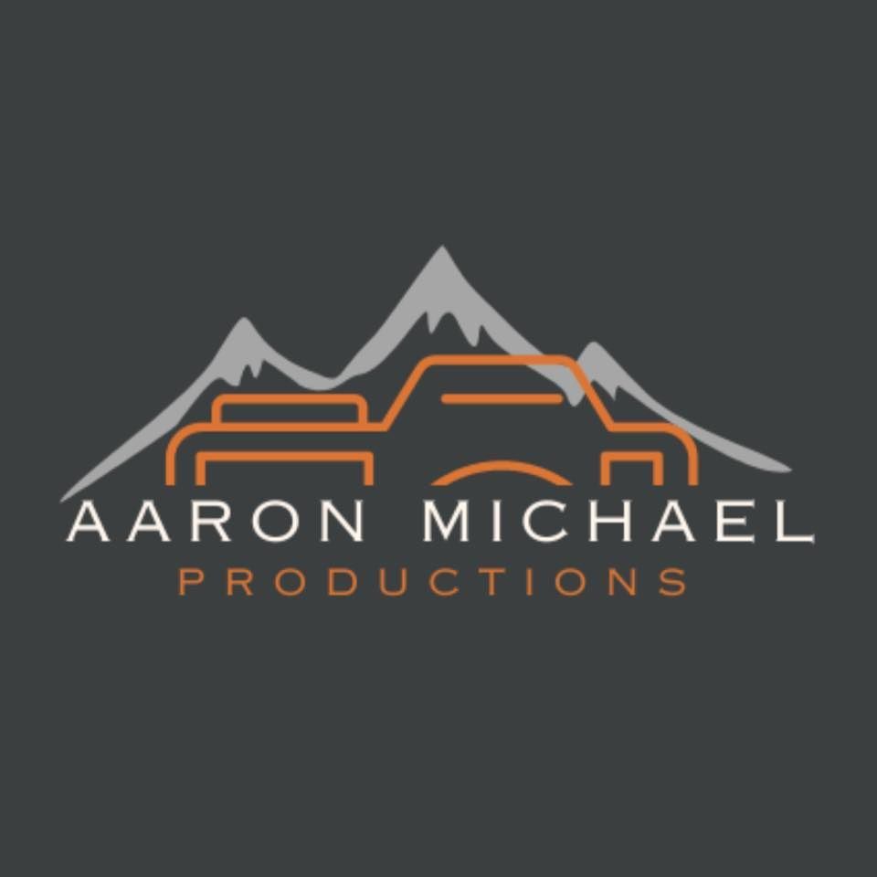 Logo for Aaron Michael Productions featuring a grey mountain silhouette above an orange line-art camera icon on a grey.