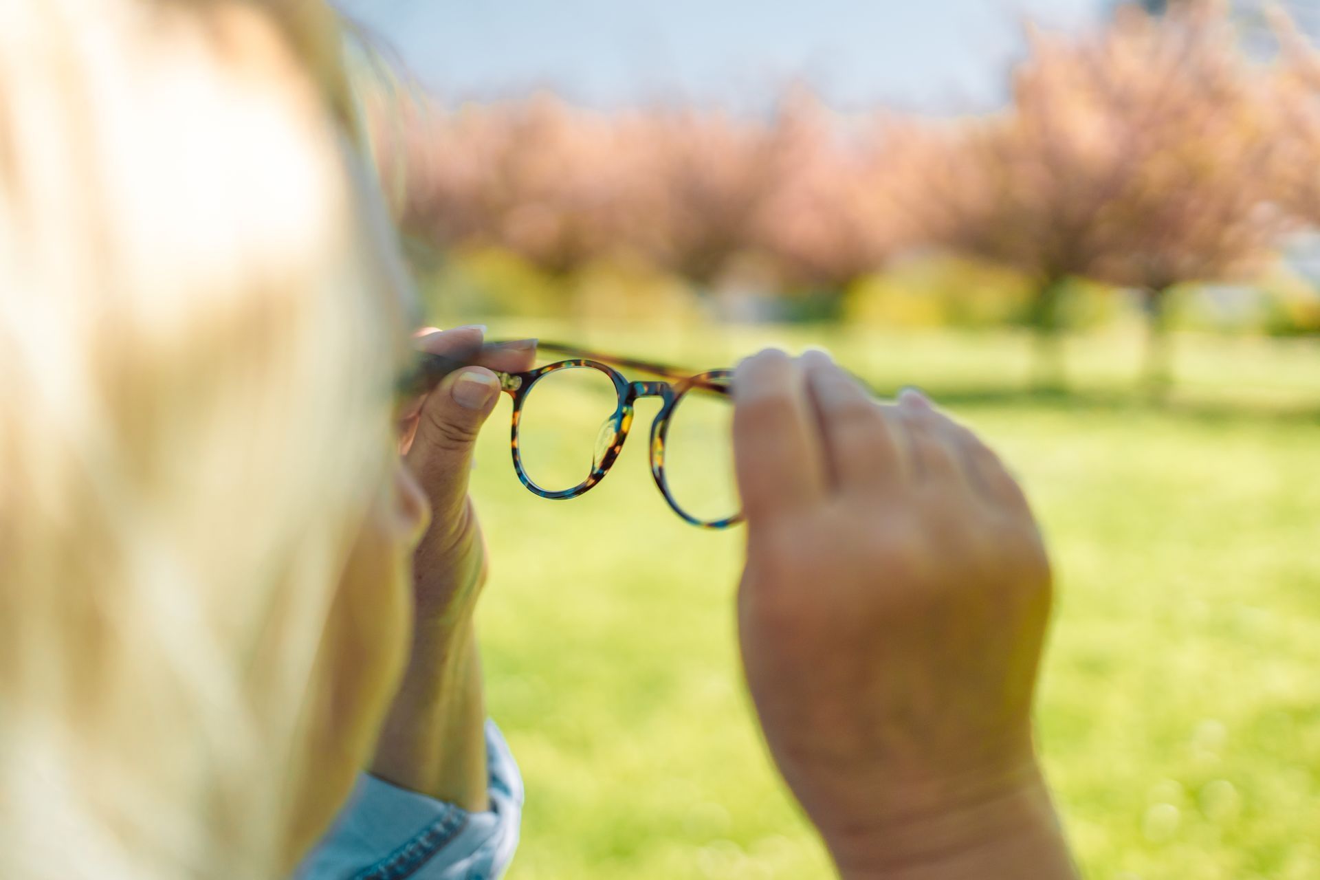 Una persona tiene in mano un paio di occhiali.