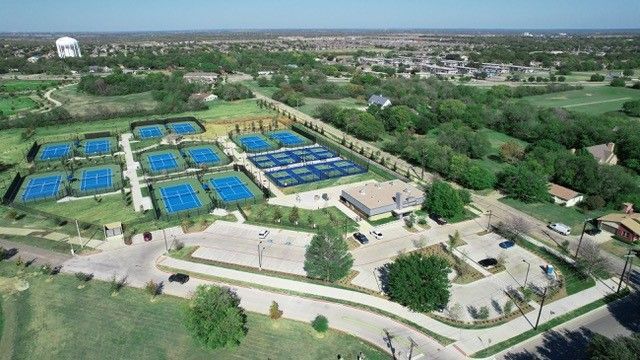 An aerial view of a tennis court with a water tower in the background.