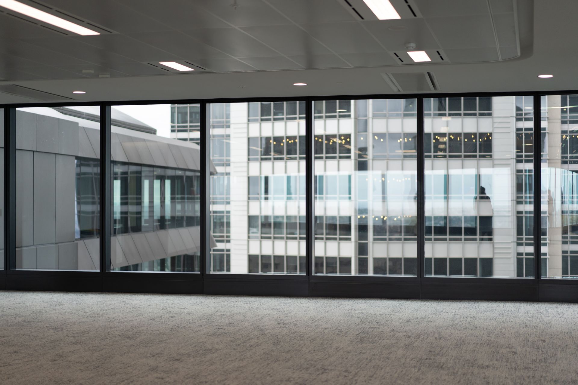 Empty office interior with large windows overlooking neighboring buildings