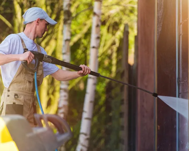 Person Using a Pressure Washer on a Wood Structure, Outdoors — MDSR Group In Manunda, QLD