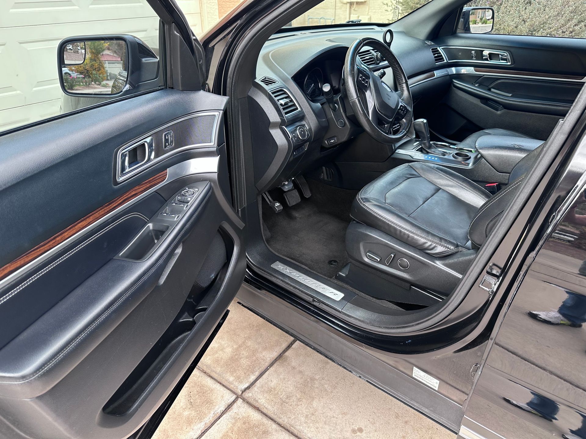 The inside of a black car with the door open.