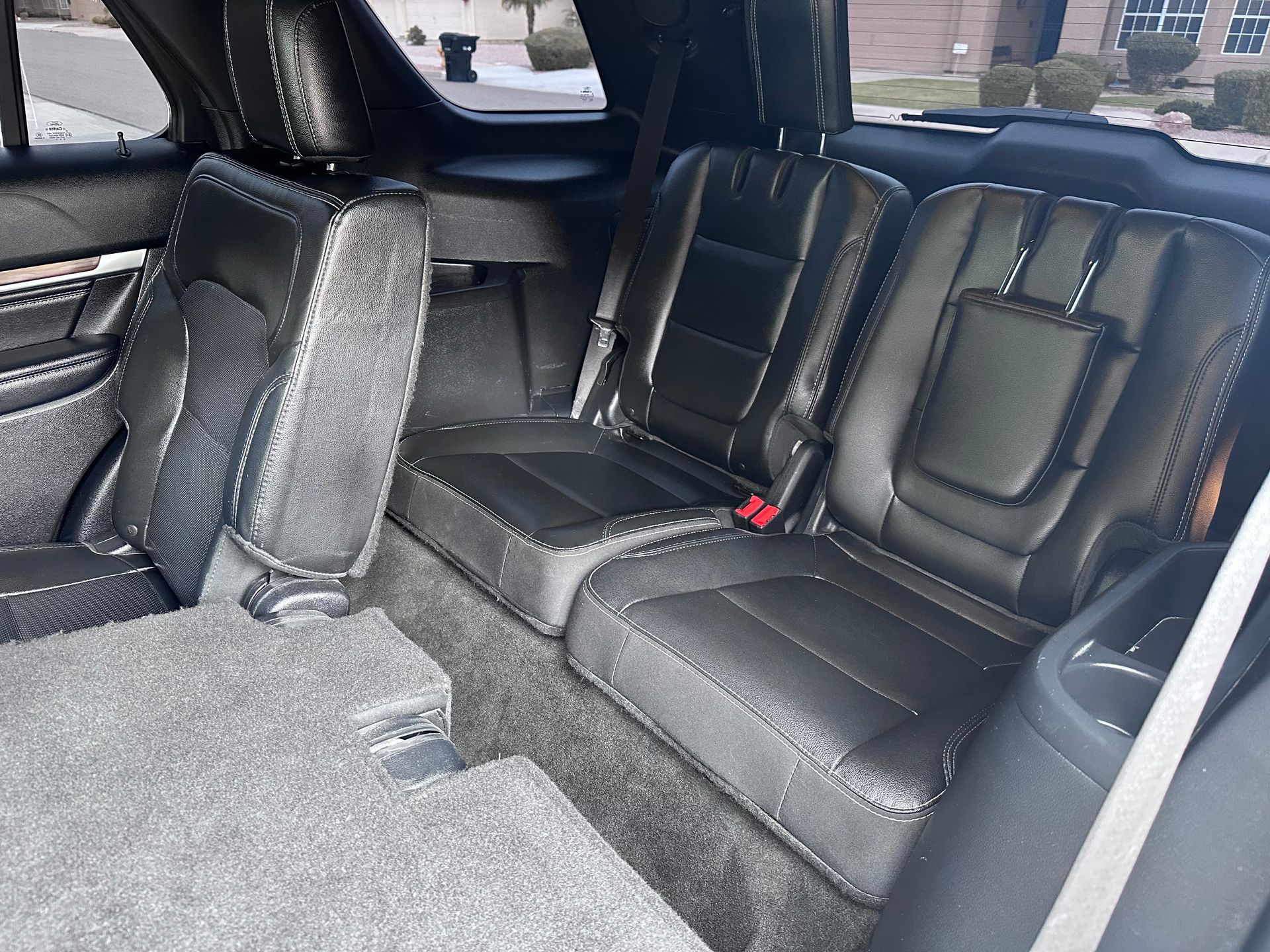 The back seat of a car with a seat belt on it