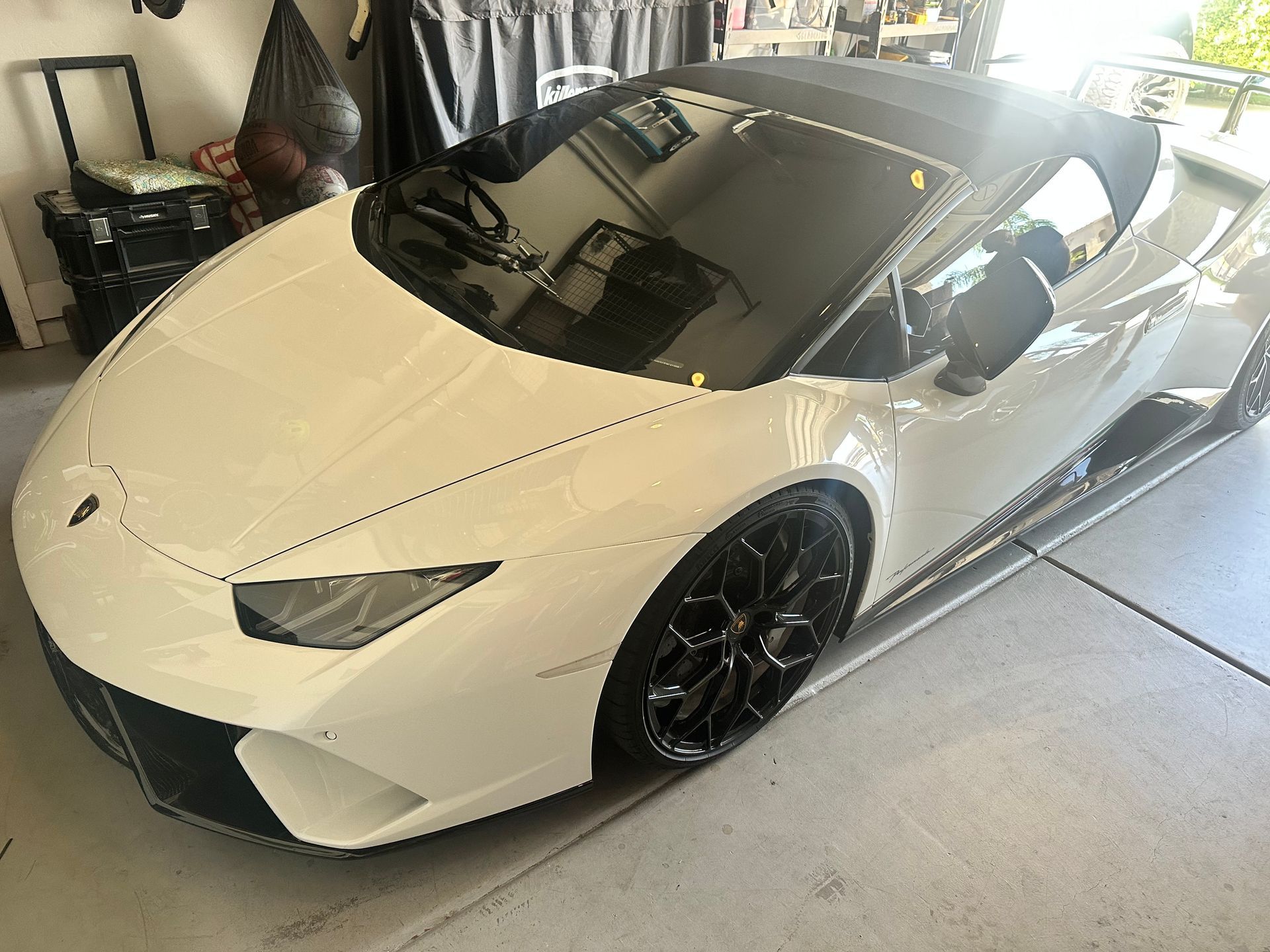 A white lamborghini huracan is parked in a garage.