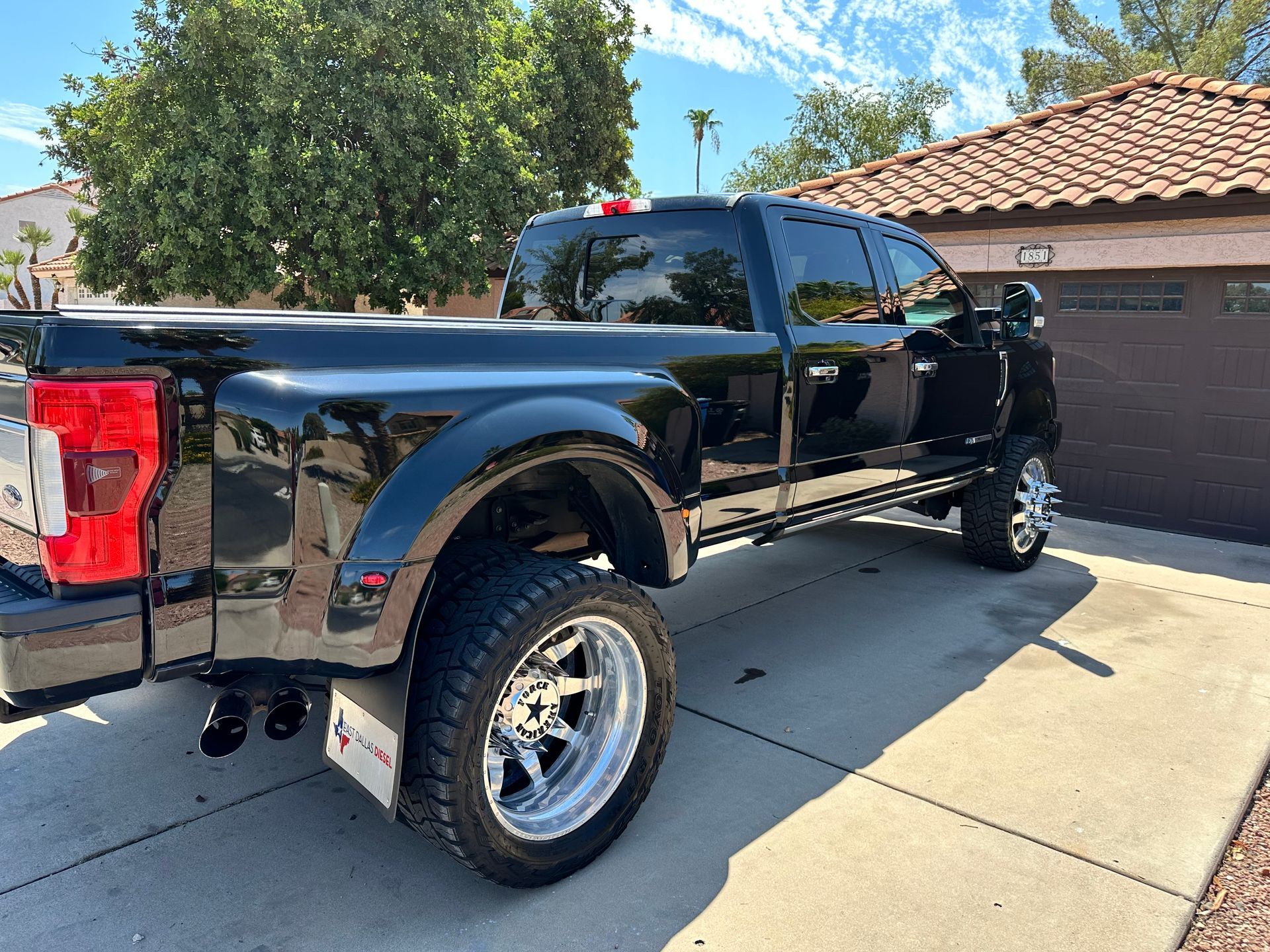 A black truck is parked in front of a garage.