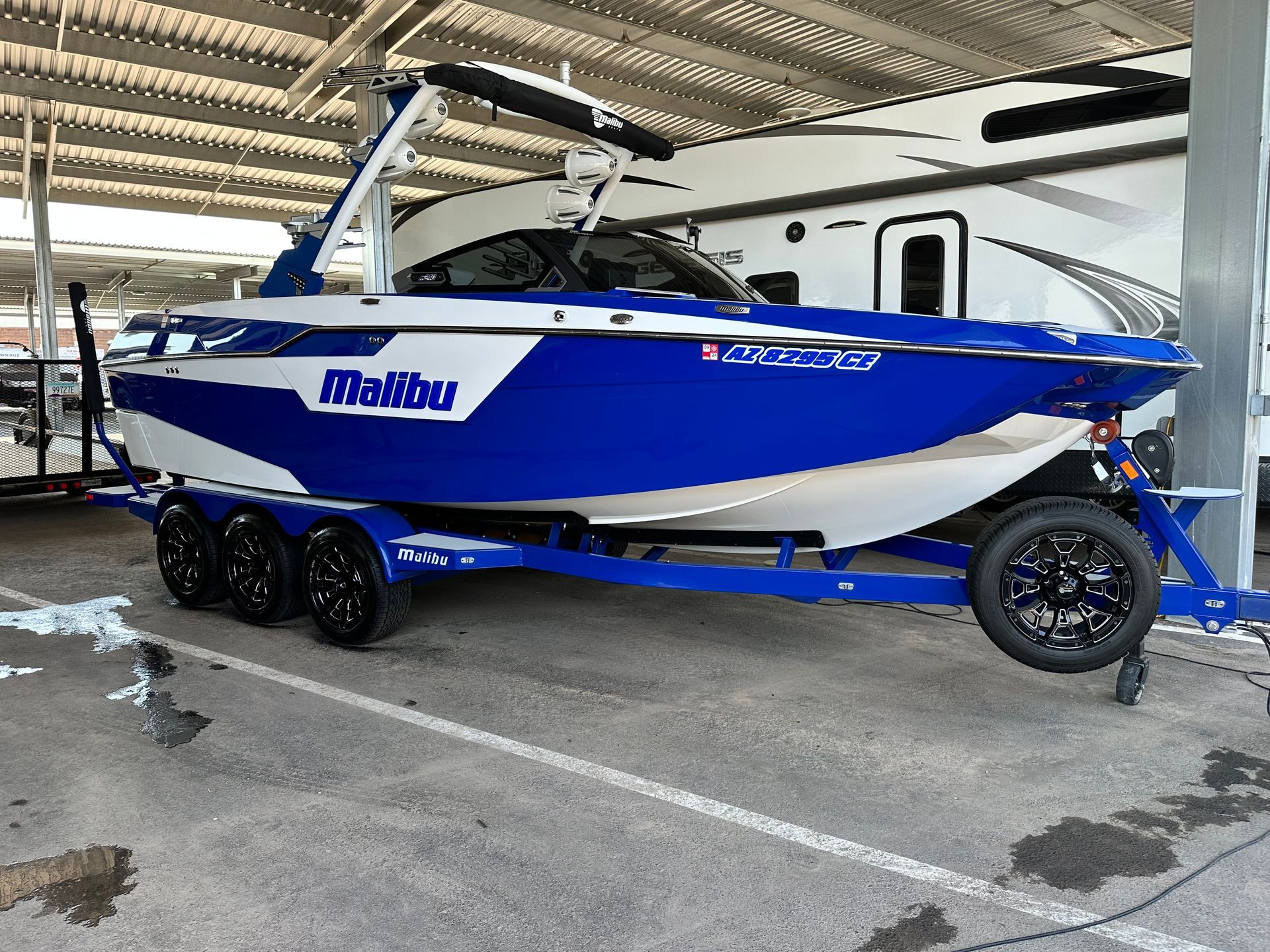 A blue and white boat is parked in a parking lot.