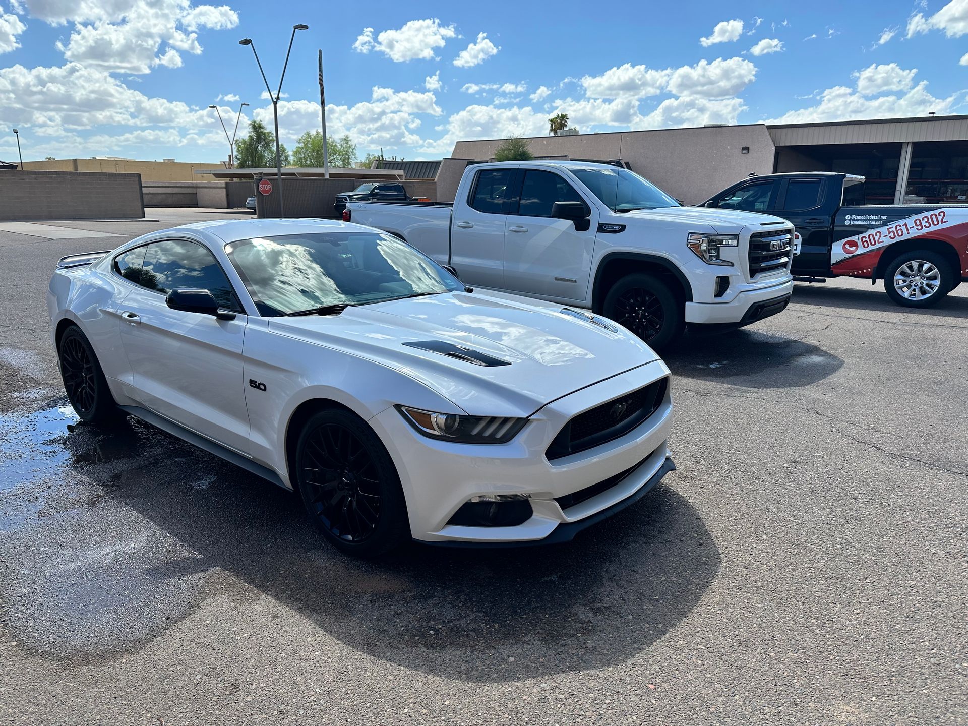 Two white cars are parked next to each other in a parking lot.