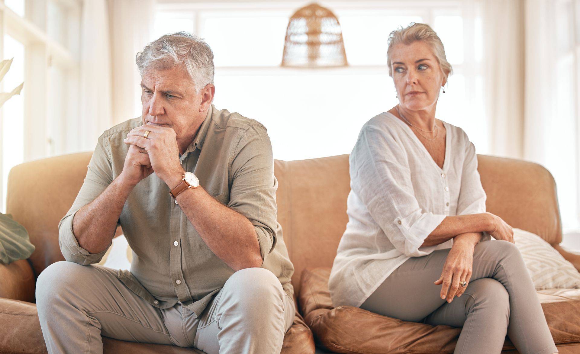 A man and a woman are sitting on a couch looking at each other.