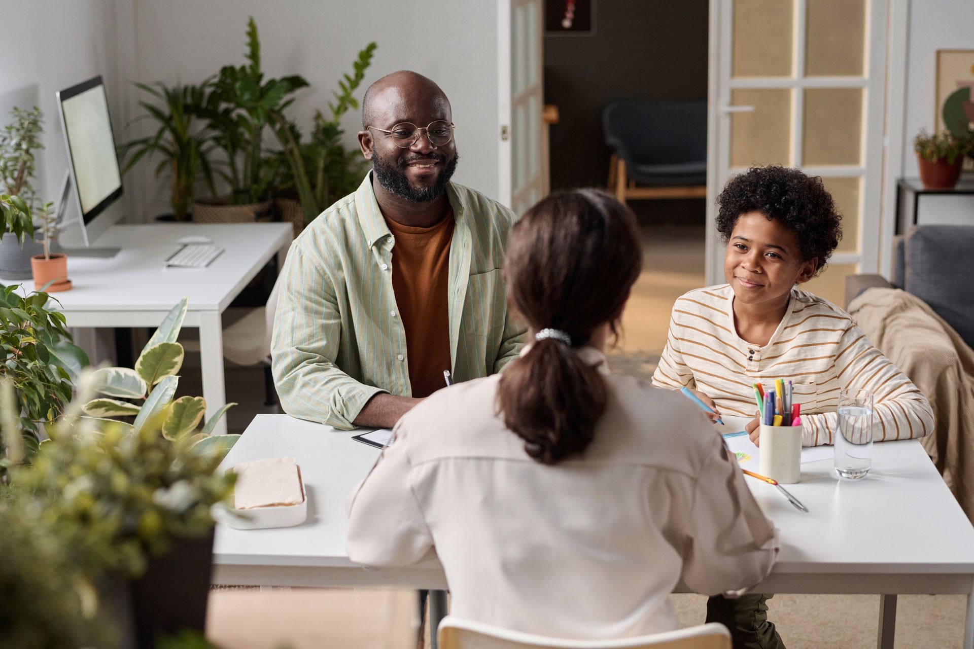A man and a woman are sitting at a table with two children.