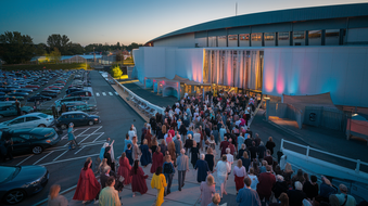 A large group of people are standing in front of a building.