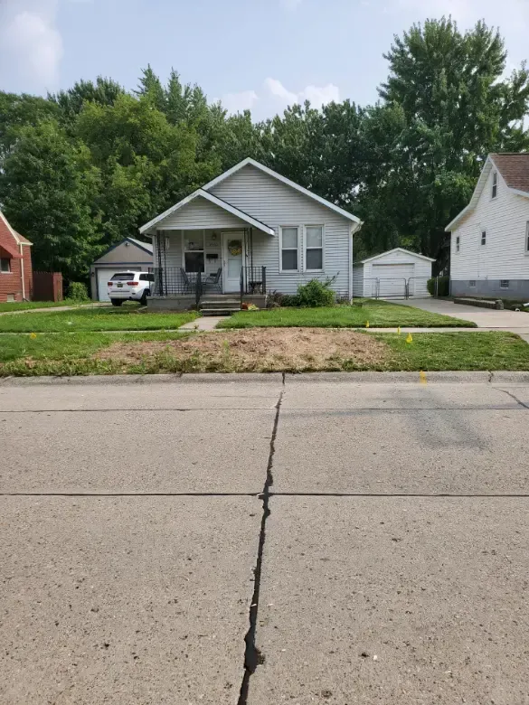 A white house with a car parked in front of it