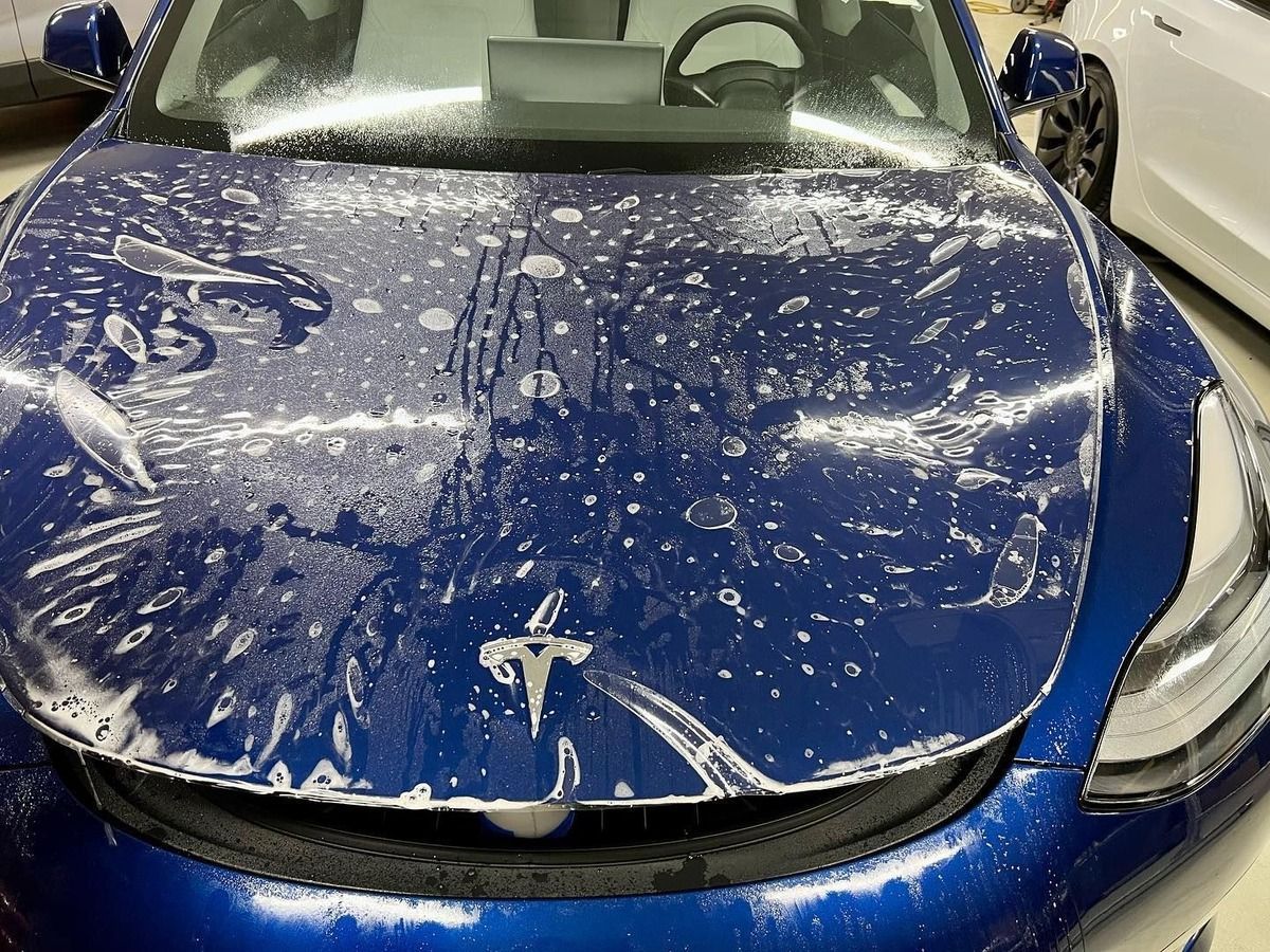 paint protection film installation on a blue Tesla