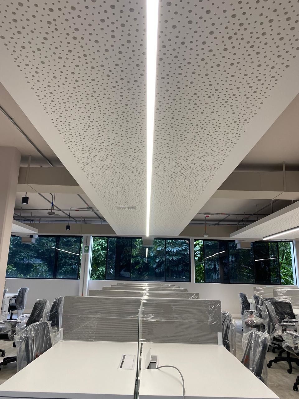 Una casa grande con muchas ventanas está situada en la cima de una exuberante ladera verde.