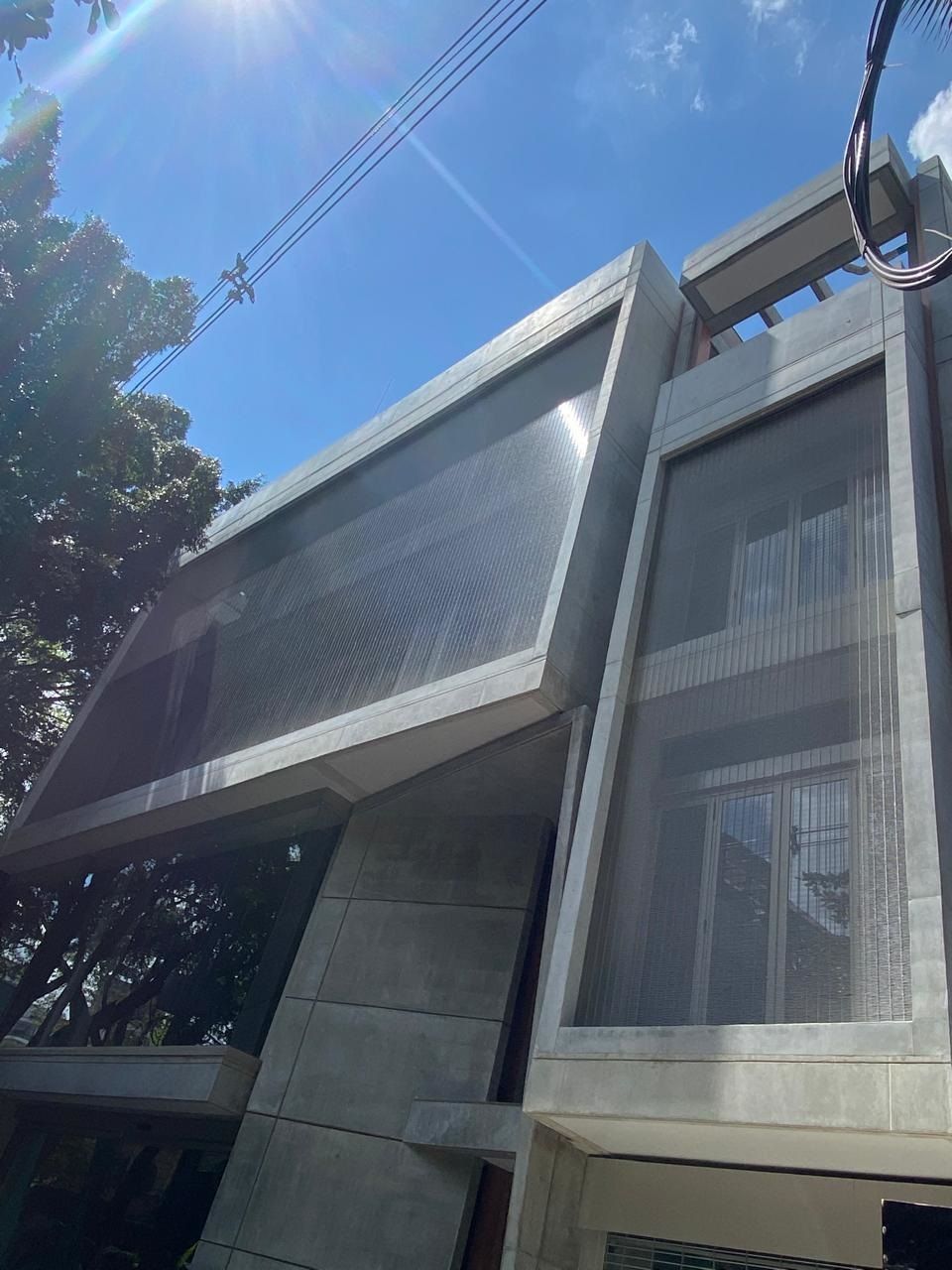 Un toldo azul sobre una ventana en el costado de un edificio.