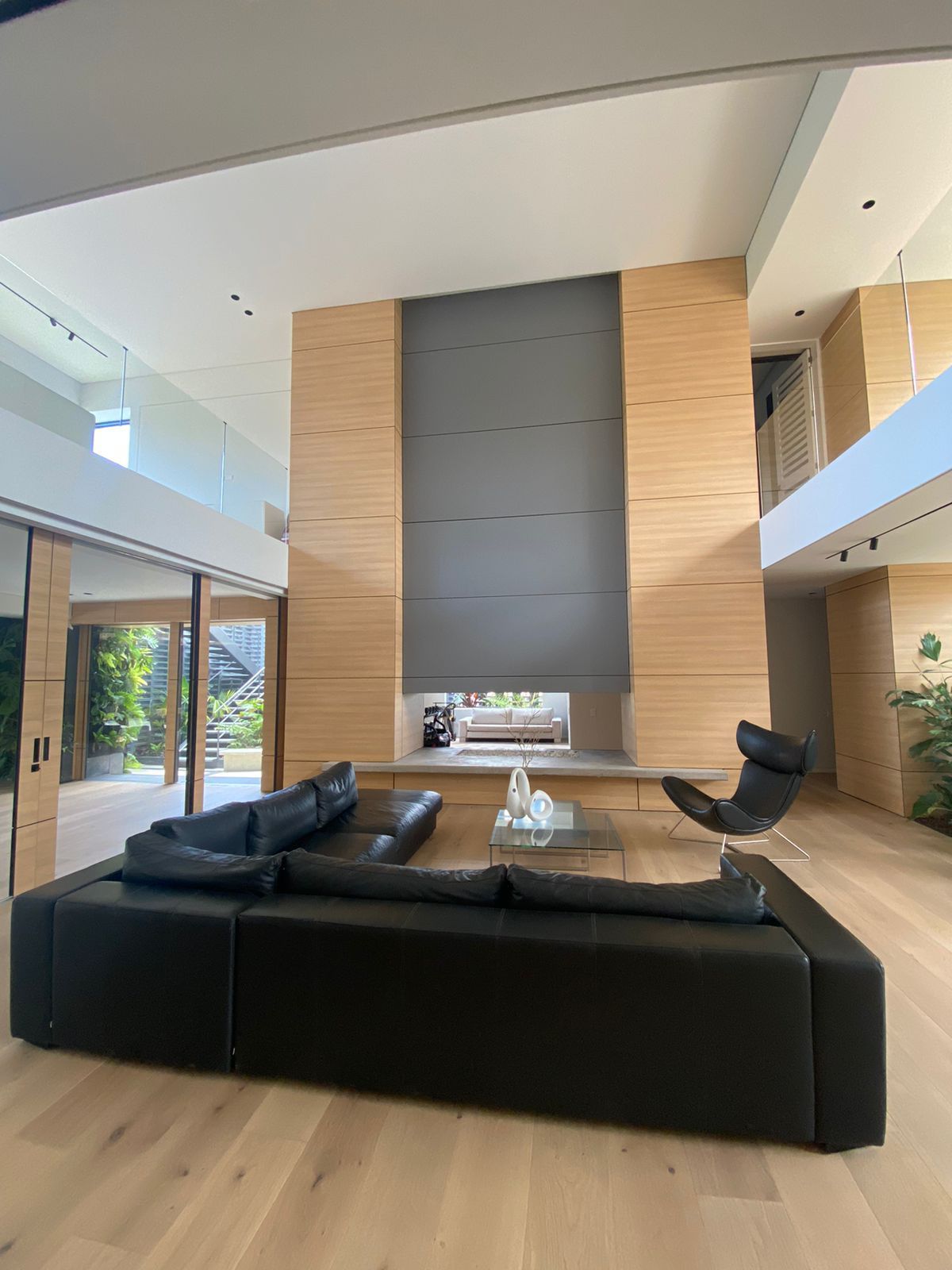 Una sala de estar con un sofá negro y una chimenea.