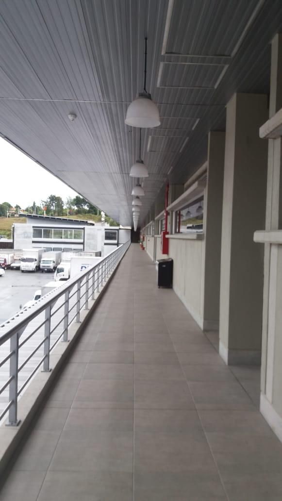 Un largo pasillo con barandilla y muchas ventanas.