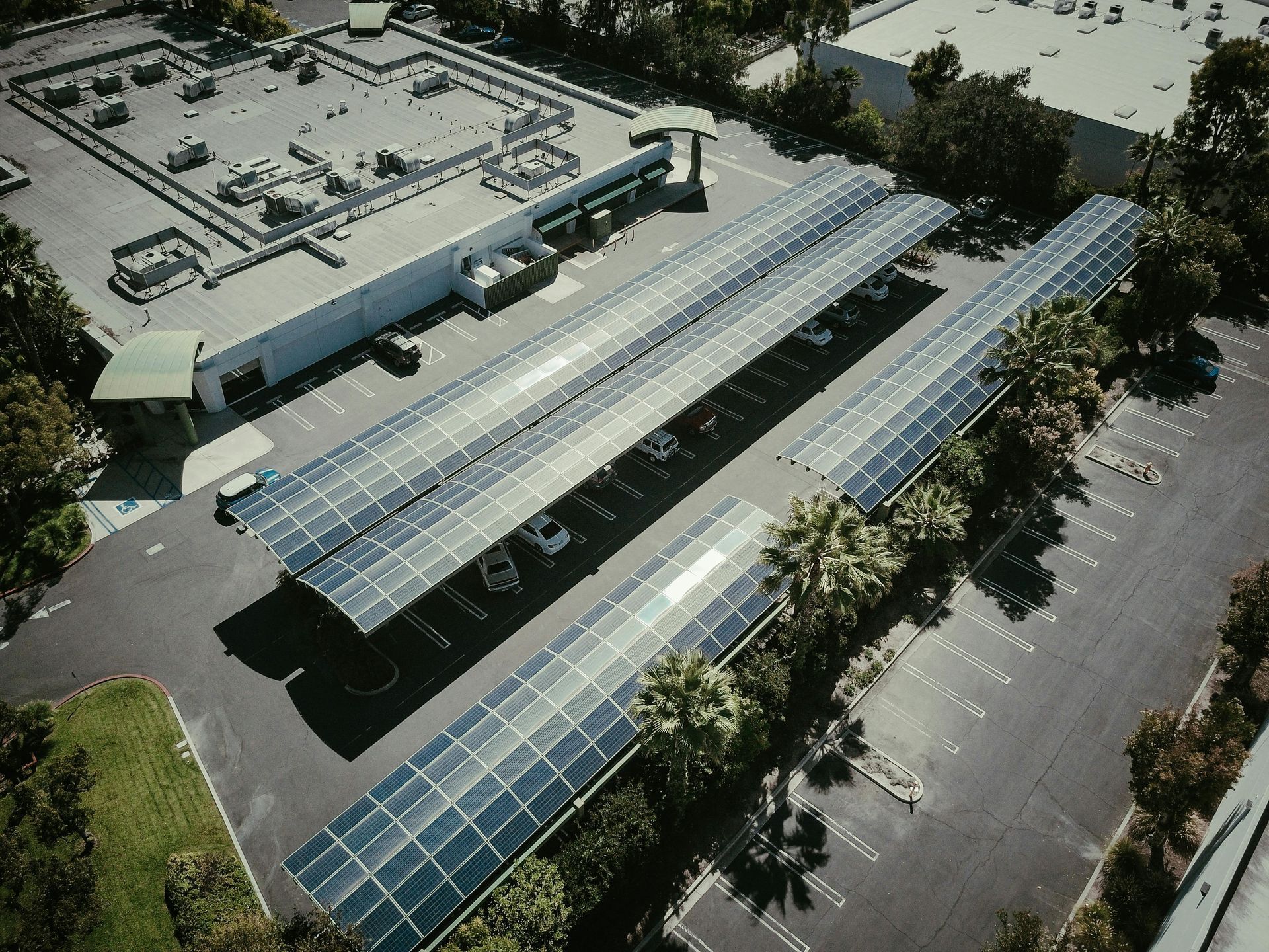 An aerial view of a parking lot with solar panels on the roof