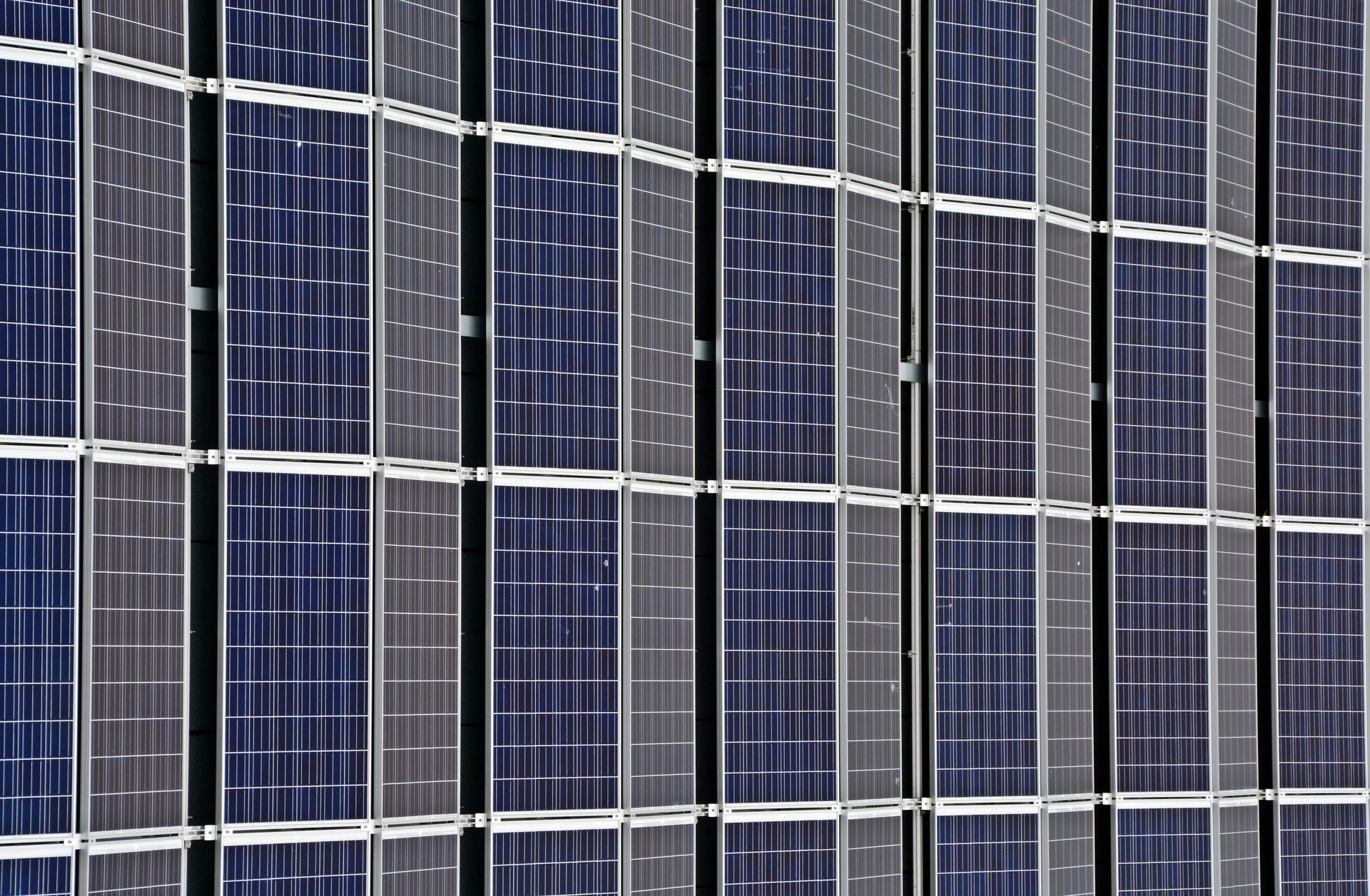 A close up of a wall of solar panels on a building