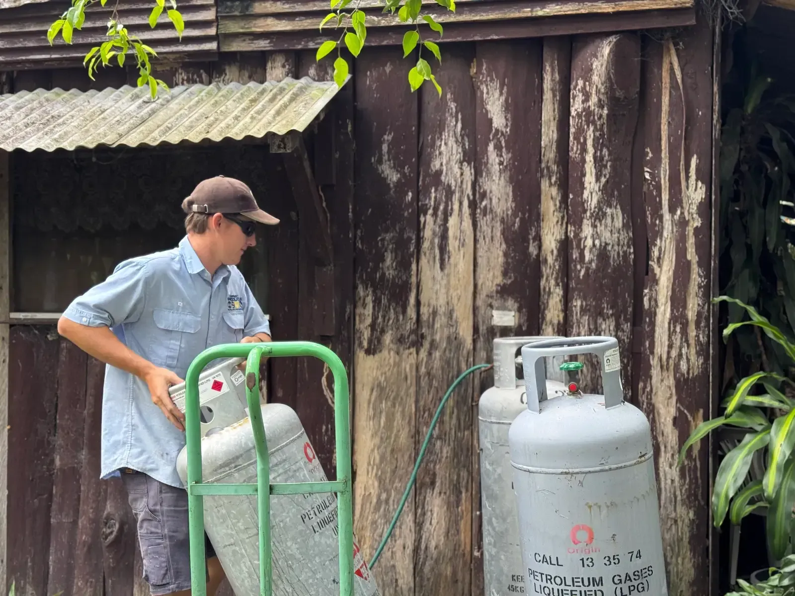 A Row of Propane Tanks Are Lined up In Front of A Brick Wall — Kempsey Produce & Saddlery in Kempsey, NSW