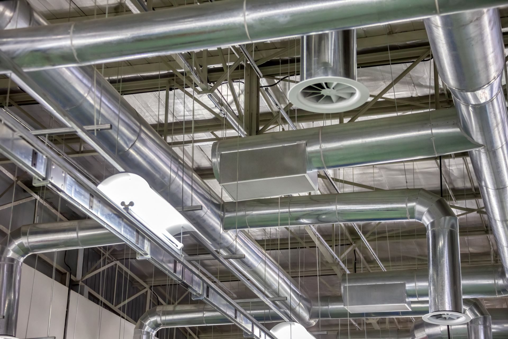 Two ceiling-mounted air conditioning units in a concrete room.