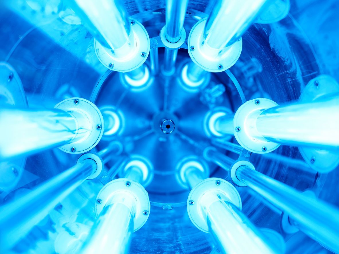 Blue UV light array inside a cylindrical chamber, for water disinfection.