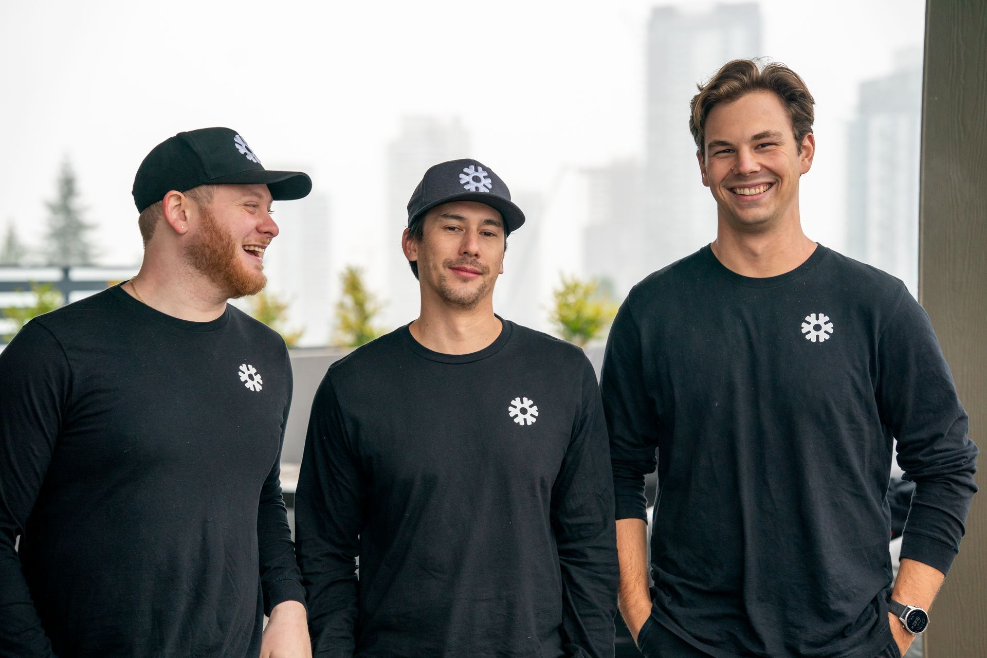 Air conditioning unit next to a house with a wooden deck and stairs, surrounded by greenery.
