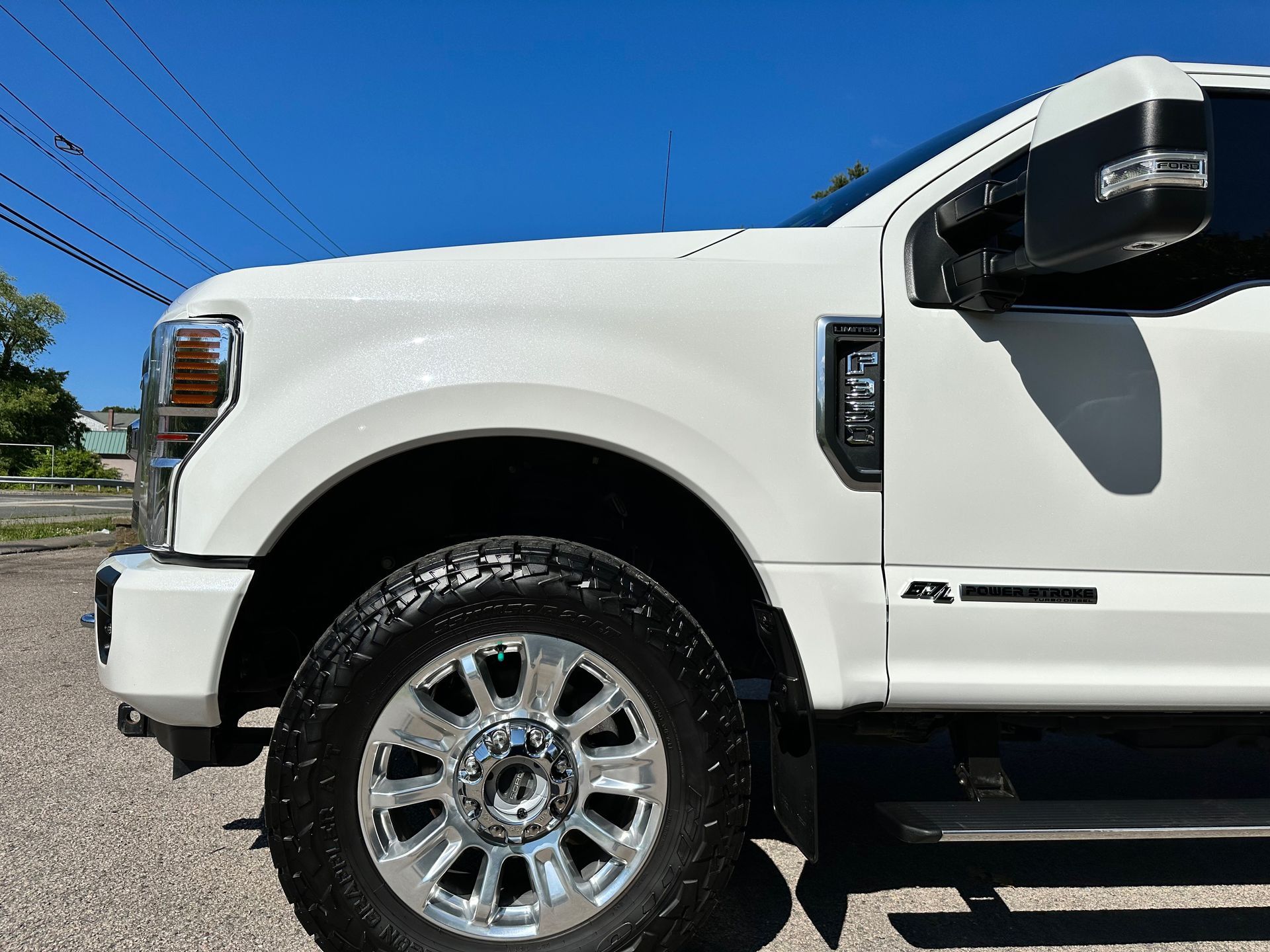 a white truck is parked on the side of the road .