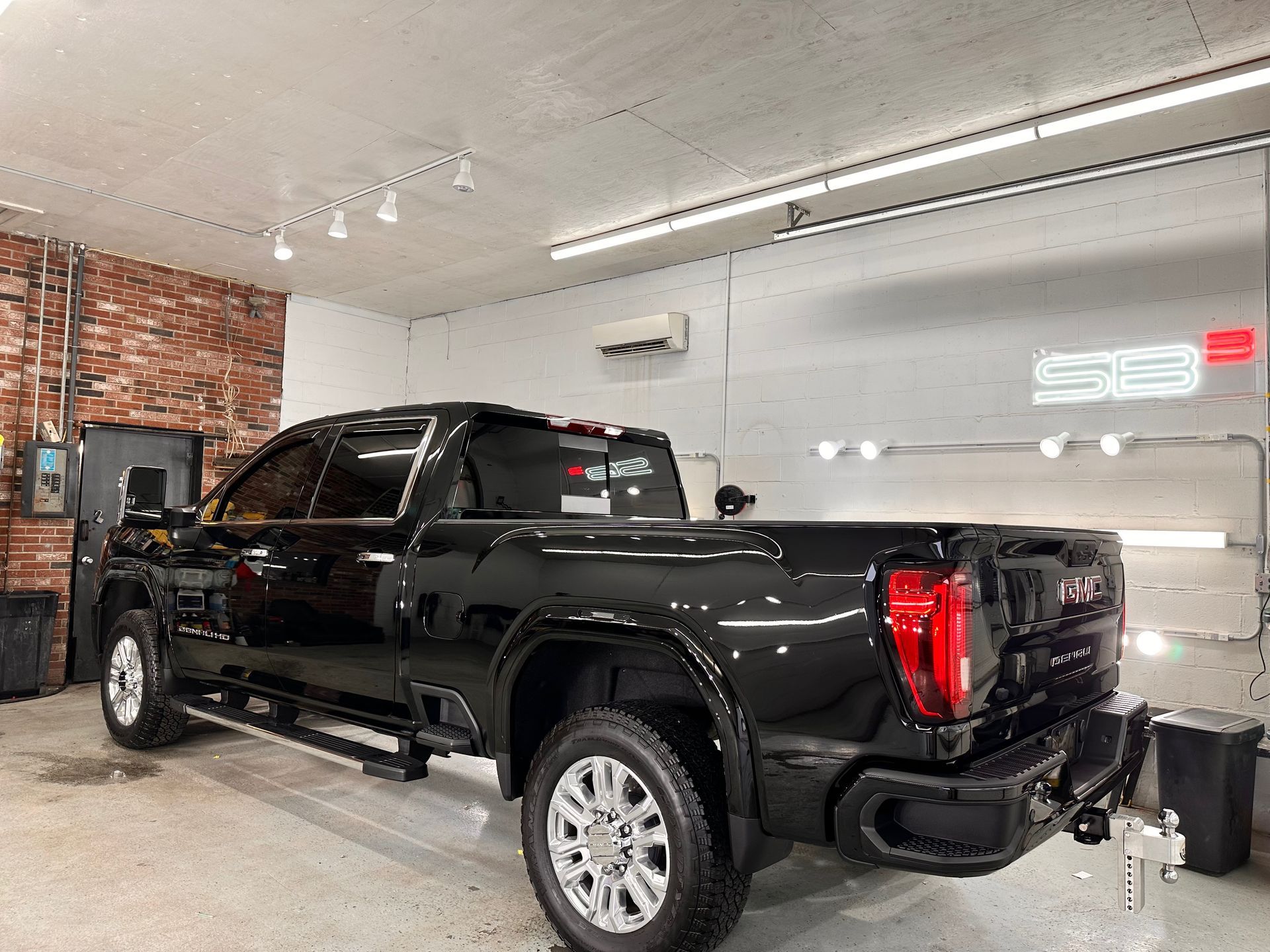 a black truck is parked in a garage .