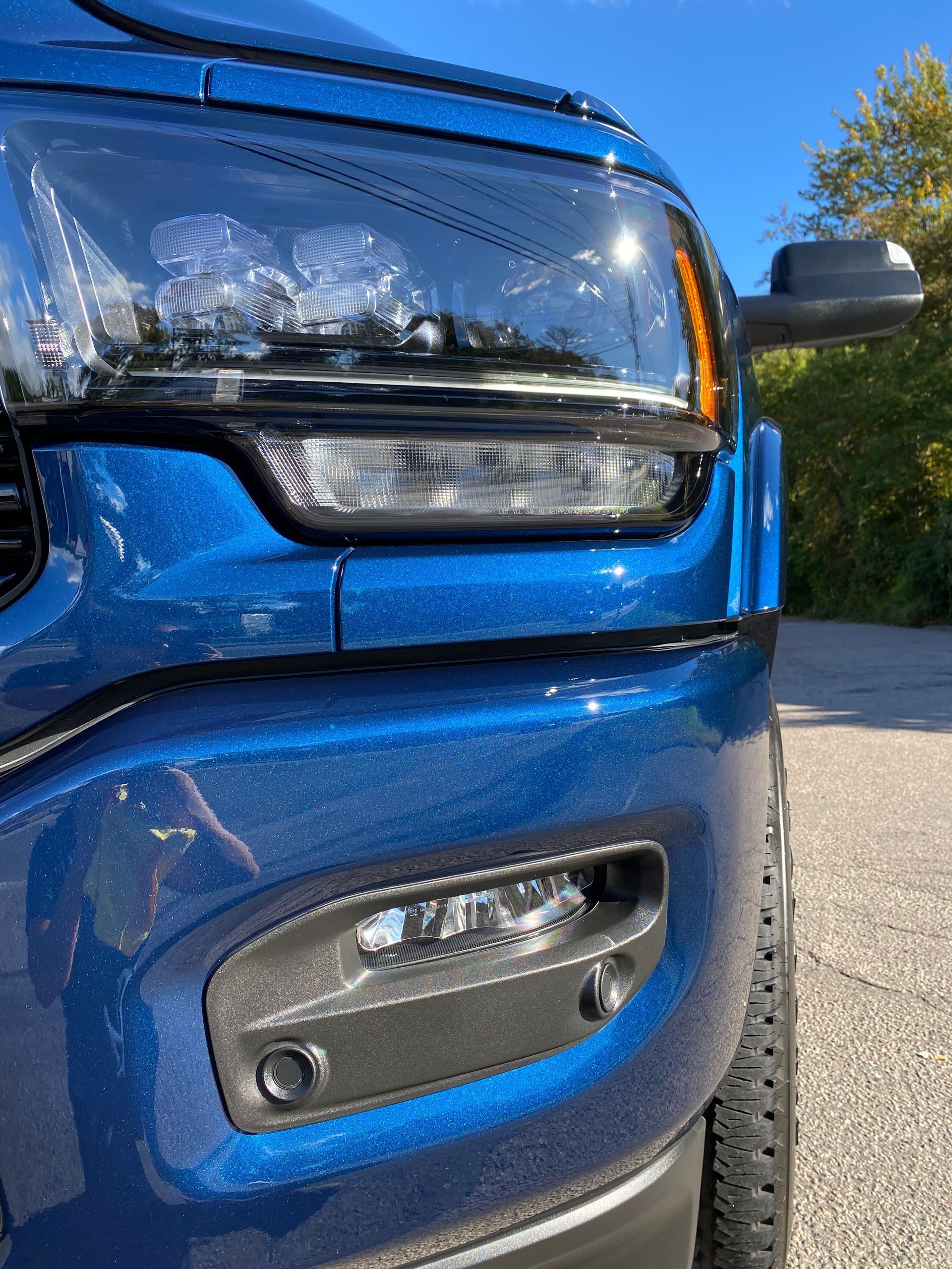 a blue truck is parked on the side of the road .