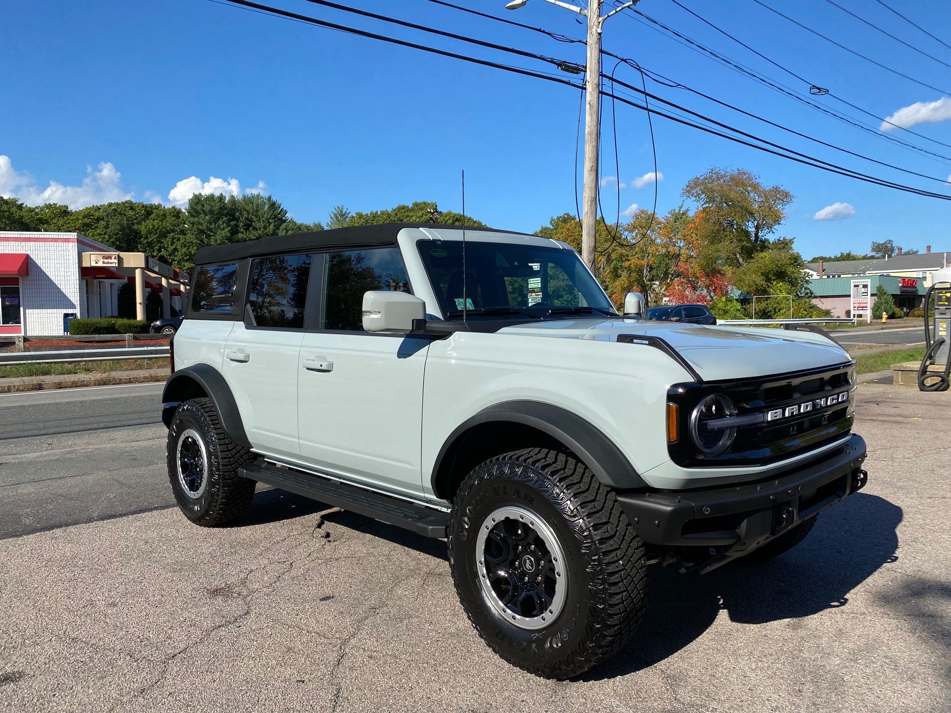 a white ford bronco is parked on the side of the road .